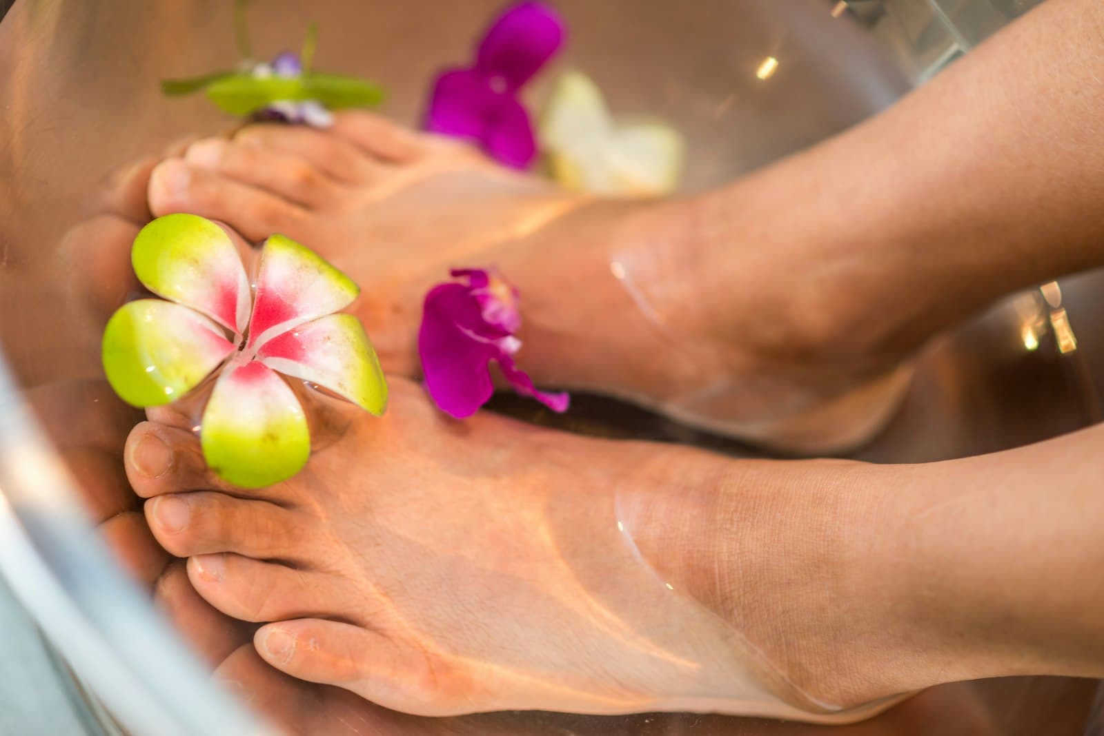 Pies en un baño de agua tibia con flores
